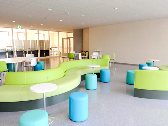 【1号館 交流ラウンジ】カラフルなインテリアの交流ラウンジ。ソファでゆっくりおしゃべりを。