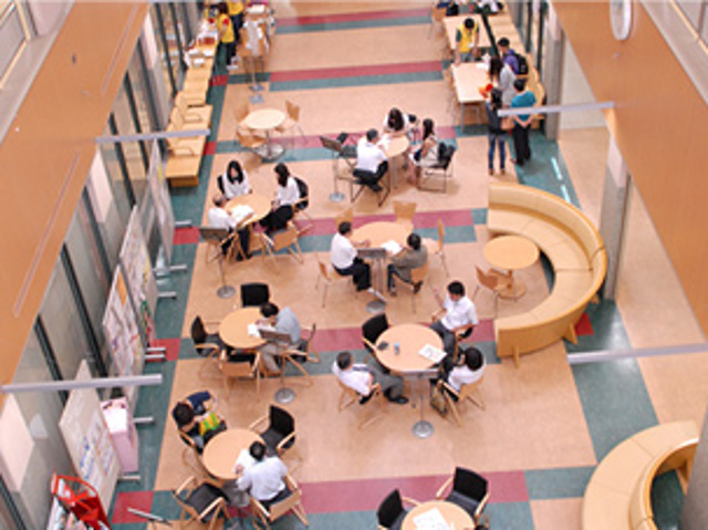 【リビングホール】9号館にある開放感あふれる憩いの空間。勉強したり、話し込んだりと、いつもみんなが思い思いに利用しています。